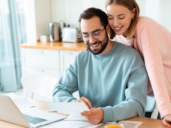 Young couple in Ireland reviewing mortgage documents and planning their first-time buyer home purchase in Cork.