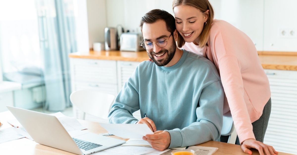 Young couple in Ireland reviewing mortgage documents and planning their first-time buyer home purchase in Cork.